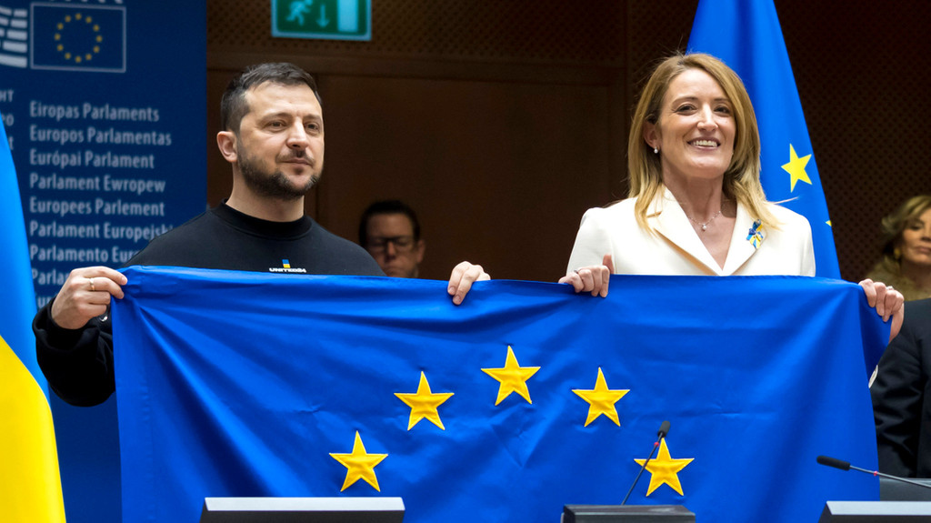 Auf diesem vom Europäischen Parlament zur Verfügung gestellten Foto halten Wolodymyr Selenskyj (l), Präsident der Ukraine, und Roberta Metsola, Präsidentin des Europäischen Parlaments, während einer Plenarsitzung im Europäischen Parlament, eine Flagge der Europäischen Union.