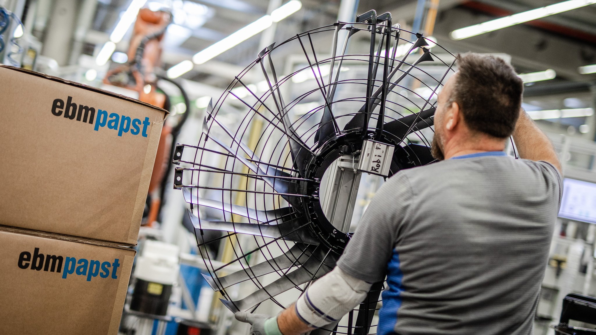 Ein Mitarbeiter des Elektromotoren- und Ventilatorenherstellers ebm-Papst steht an einem Ventilator.