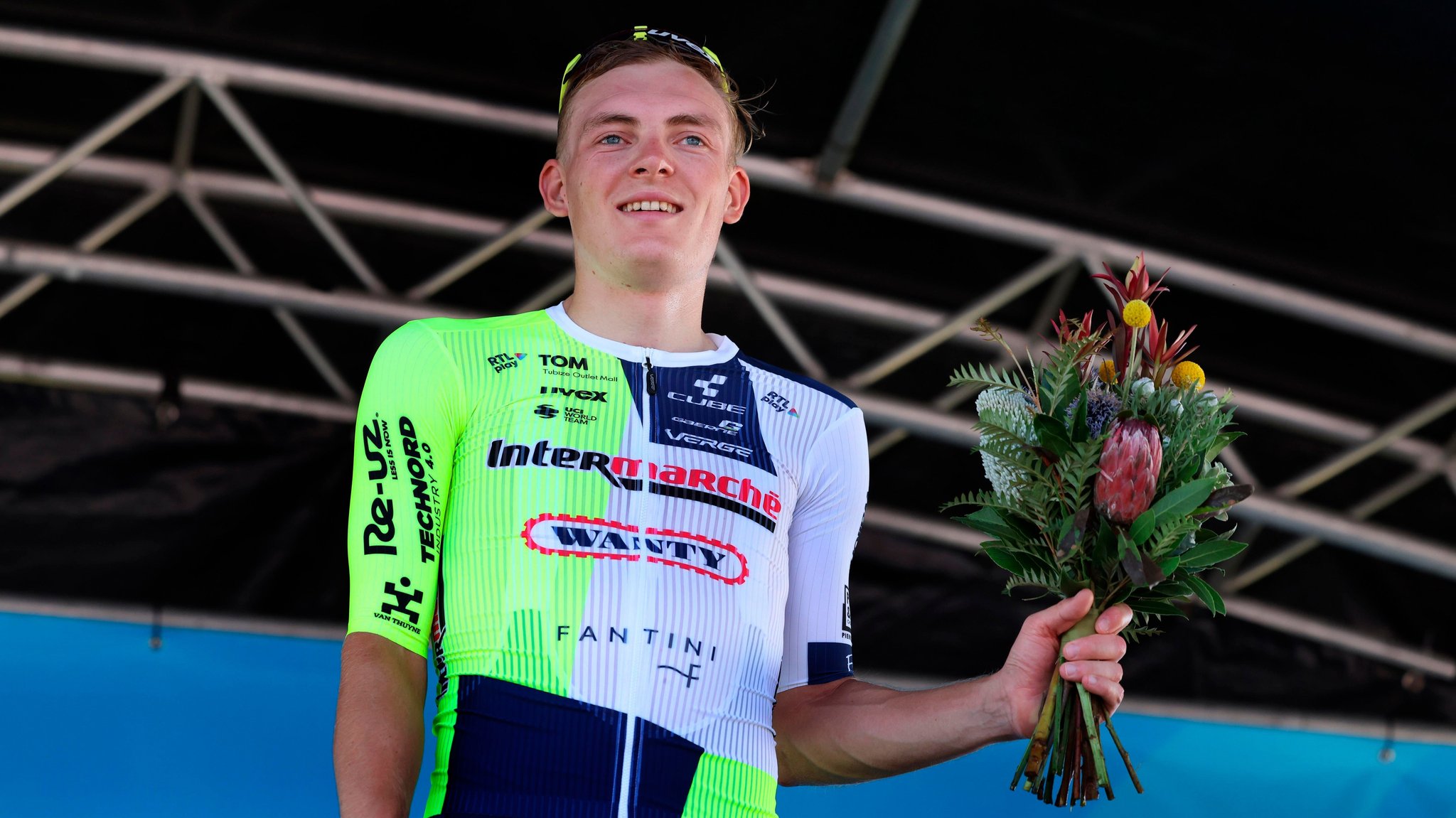 Radprofi Georg Zimmermann bei der Siegerehrung in Australien mit Blumenstrauß in der Hand