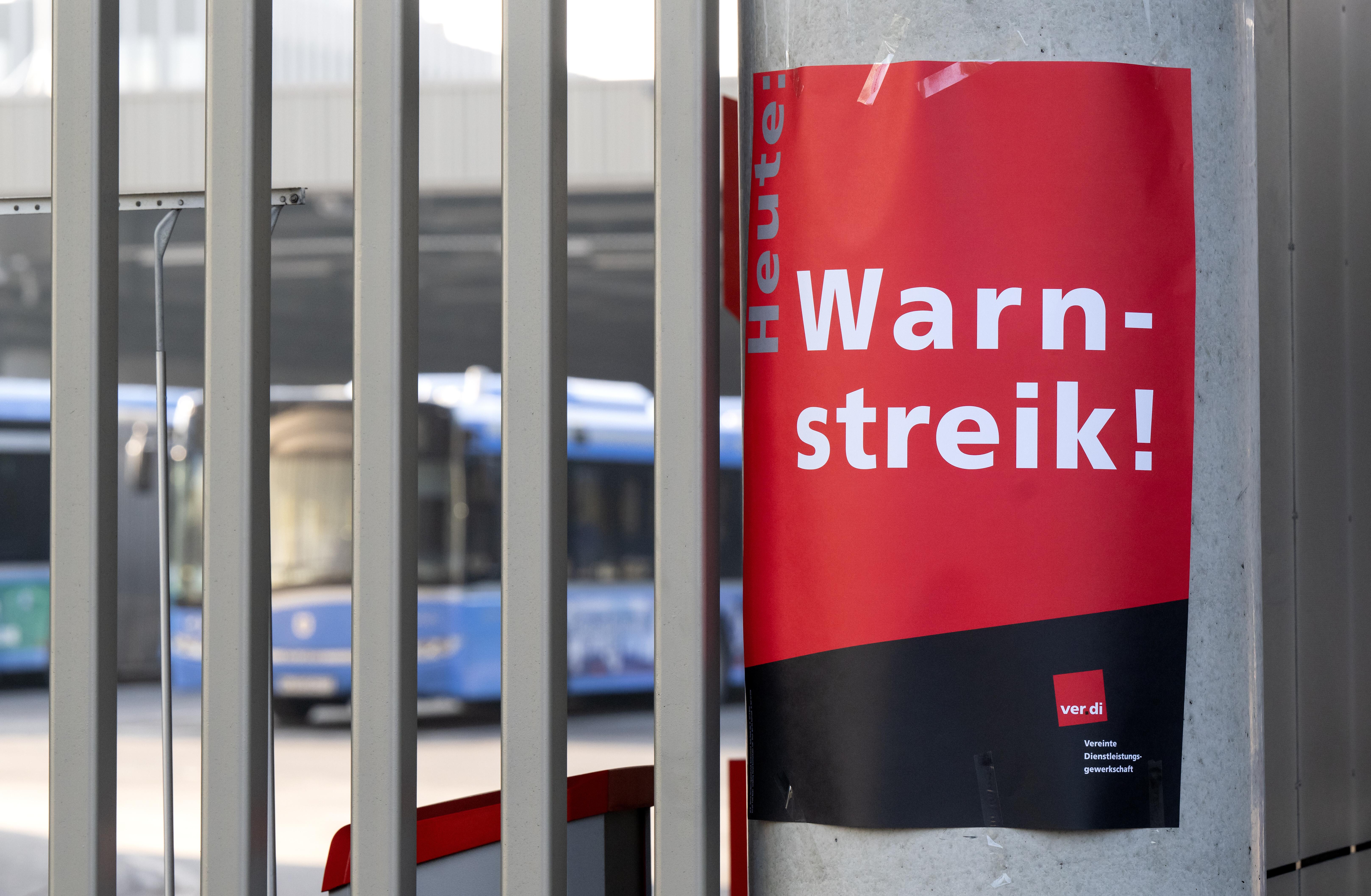 Ein Zettel mit der Aufschrift "Heute Warnstreik!" ist an der Zufahrt von einem Busdepot zu sehen.