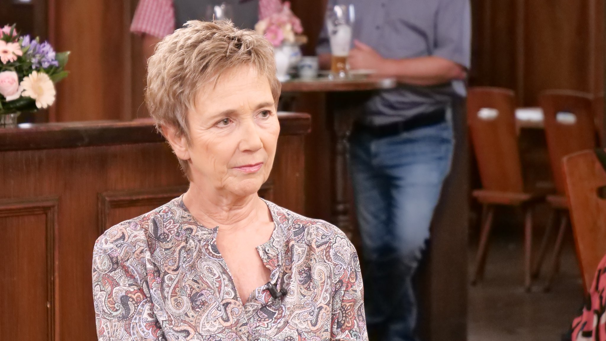 Amelie Fried sitzt am Sonntags-Stammtisch. Die Kulisse ist wie ein Gasthaus gestaltet. Amelie Fried hat kurze, blonde Haare und trägt eine gemusterte Bluse. | Bild: Andreas Schroll / Bayerischer Rundfunk 2026 Amelie Fried sitzt am Sonntags-Stammtisch. Die Kulisse ist wie ein Gasthaus gestaltet. Amelie Fried hat kurze, blonde Haare und trägt eine gemusterte Bluse.