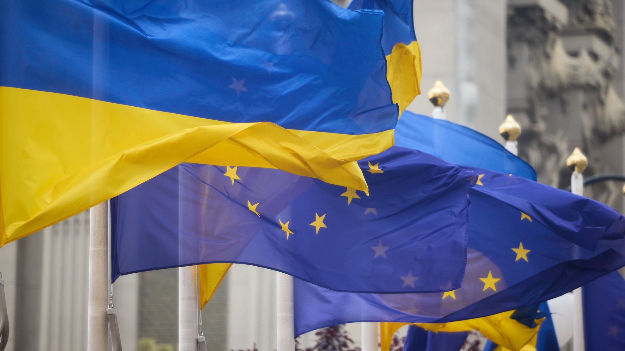 Ukrainische Flagge weht im Wind neben der europäischen Flagge (Symbolbild)