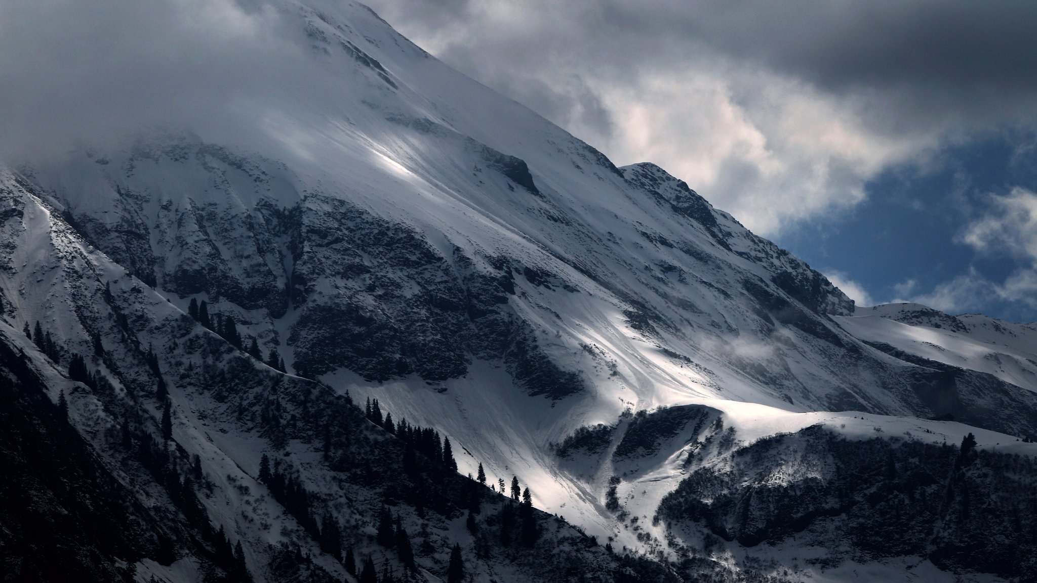 Wolken ziehen über den schneebedeckten Linkerskopf bei Oberstdorf