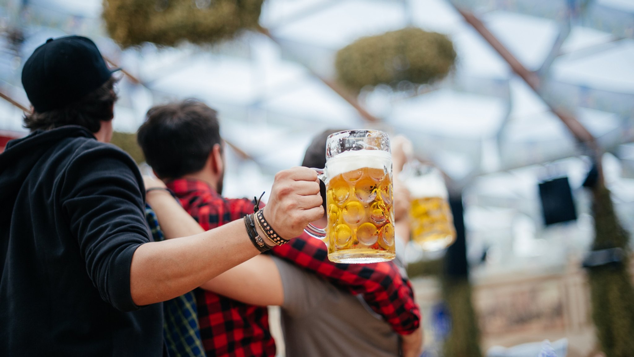 Männer mit Maßkrügen im Bierzelt (Symbolbild).