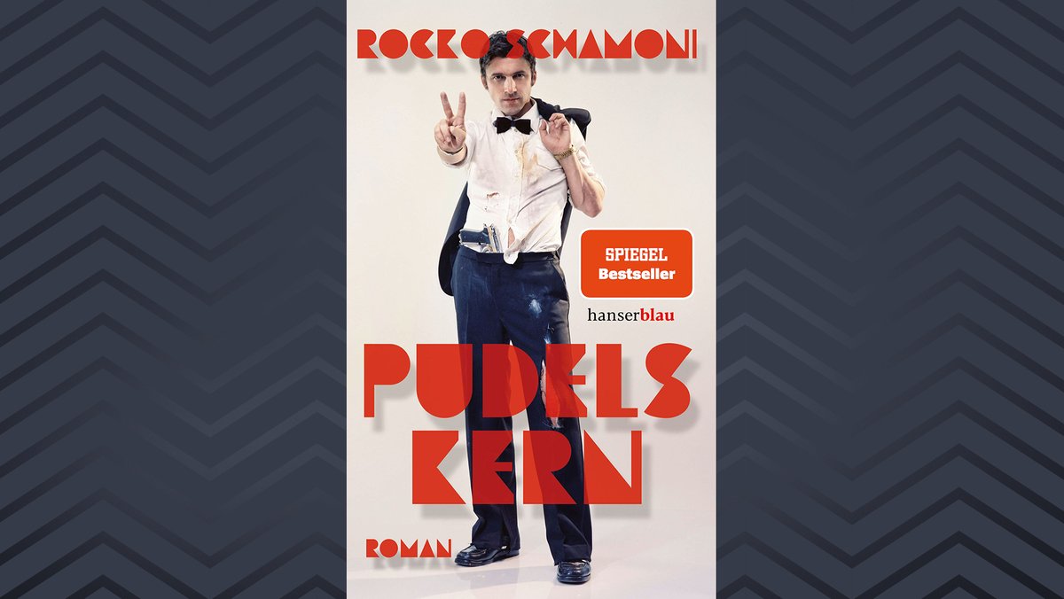Buchcover von Rocko Schamonis neuem Buch "Pudels Kern": Auf dem Cover Rocko Schamoni in zerschlissenem Hemd und Fliege mit Pistole im Hosenbund.