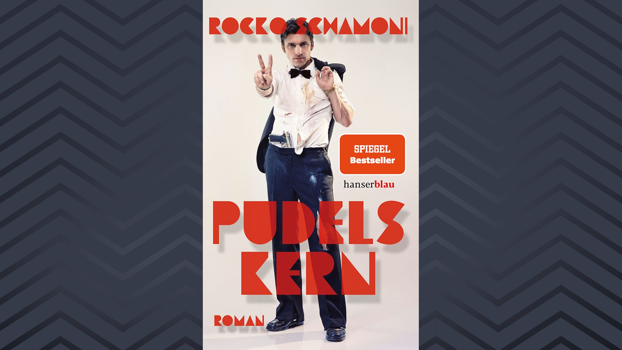 Buchcover von Rocko Schamonis neuem Buch "Pudels Kern": Auf dem Cover Rocko Schamoni in zerschlissenem Hemd und Fliege mit Pistole im Hosenbund.