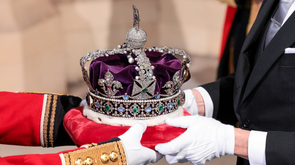 Die Imperial State Crown wird vor der Eröffnung des Parlaments im House of Lords am Eingang des Souveräns zum Palace of Westminster übergeben.