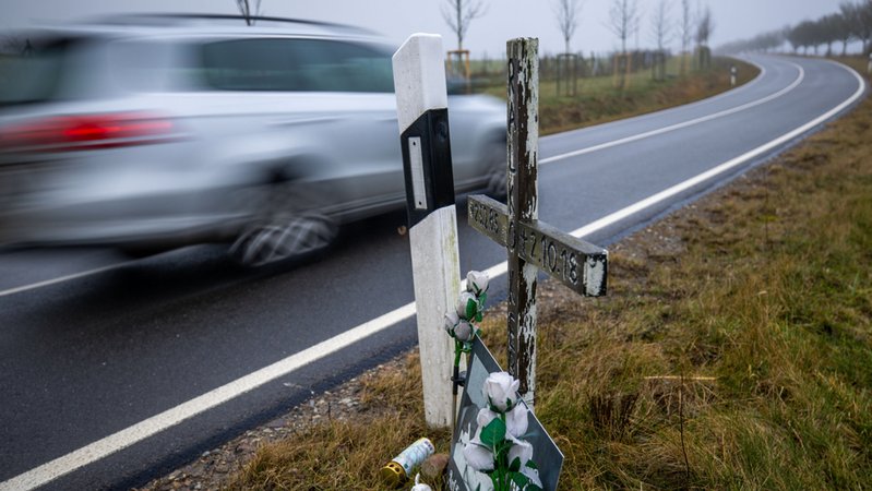 Ein Auto fährt auf einer Landstraße an einem Kreuz für ein Unfallopfer vorbei (Symbolbild). | Bild: dpa-Bildfunk/Jens Büttner Ein Auto fährt auf einer Landstraße an einem Kreuz für ein Unfallopfer vorbei (Symbolbild).