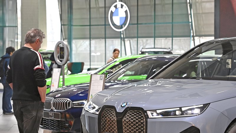 Ein Mann steht im Showroom vor Neuwagen und schaut sie sich an. | Bild: picture alliance / SVEN SIMON | Frank Hoermann / SVEN SIMON Ein Mann steht im Showroom vor Neuwagen und schaut sie sich an.