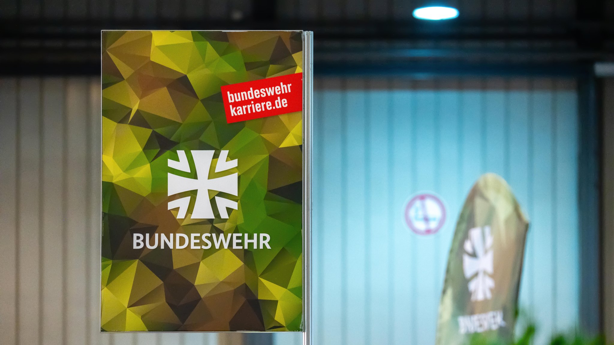 ARCHIV (07.03.2025): Bundeswehr-Rekrutierungsplakat mit Tarnmuster-Design als Teil eines Infostands. Auf der Afair-Messe in Augsburg.
