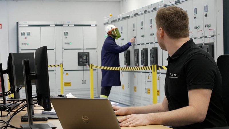 Mann sitzt an Laptop vor Batteriespeichern | Bild: BR Mann sitzt an Laptop vor Batteriespeichern
