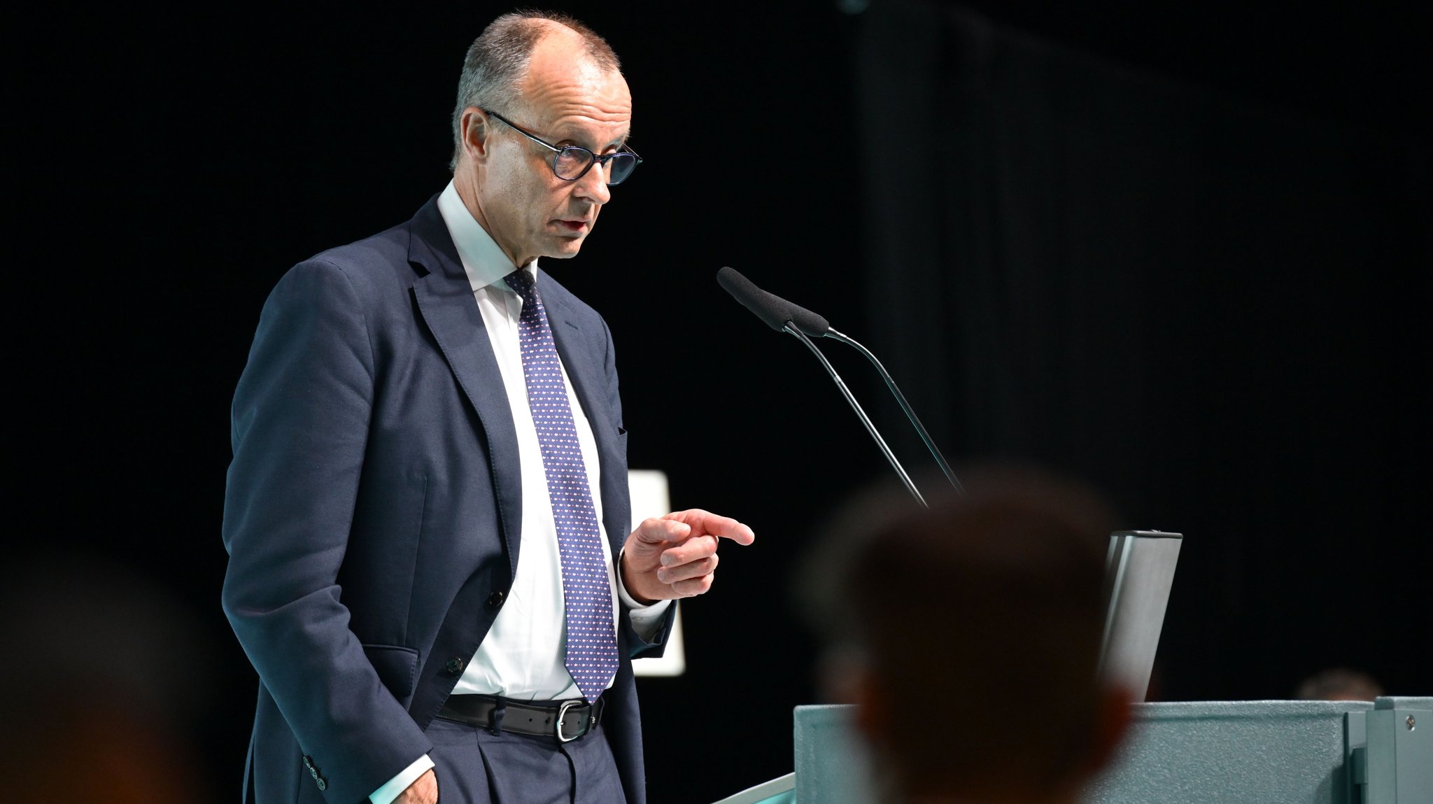 Bundeskanzler Friedrich Merz (CDU) spricht zum Wahlkampfendspurt der CDU in Baden-Württemberg in der Oberschwabenhalle auf der Bühne. | Bild: dpa-Bildfunk/Felix Kästle Bundeskanzler Friedrich Merz (CDU) spricht zum Wahlkampfendspurt der CDU in Baden-Württemberg in der Oberschwabenhalle auf der Bühne.