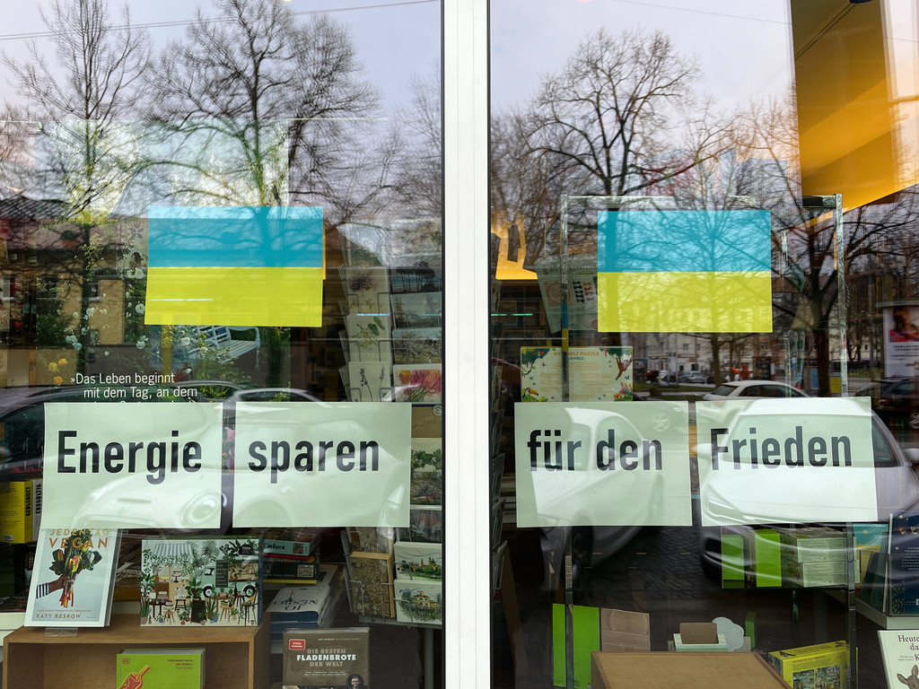 Schriftzug Energiesparen für den Frieden im Schaufenster einer Buchhandlung in München 