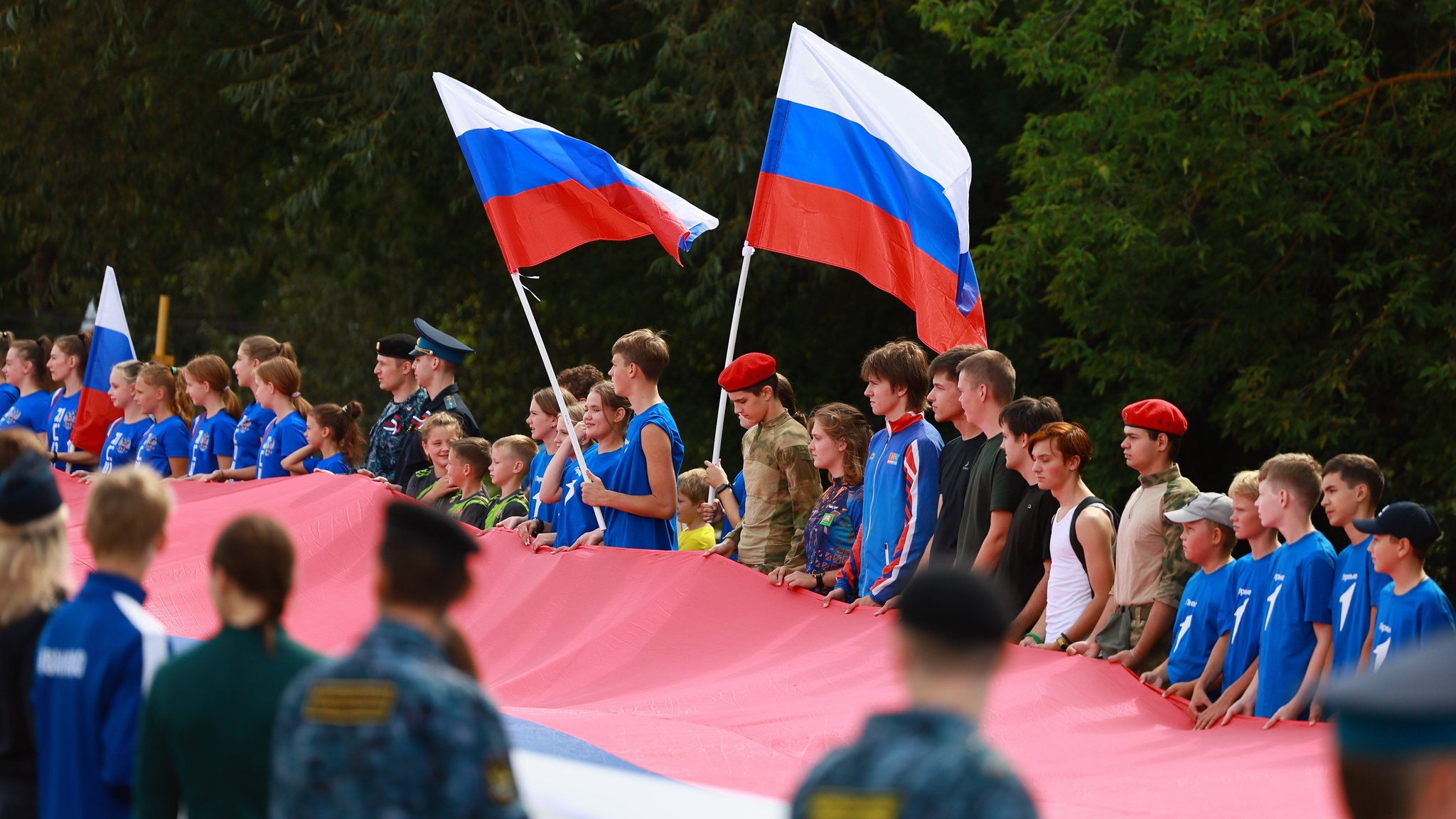 Junge Menschen halten eine überdimensionale russische Fahne 