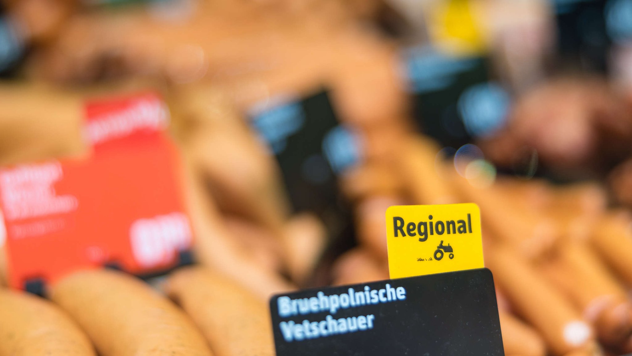 Produkte in einer Wurst-Bedienungstheke in einem Supermarkt, die teilweise Hinweise auf eine regionale Herkunft tragen (Symbolbild)