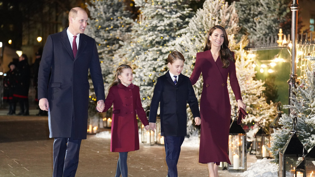 Großbritanniens Prinz William und seine Frau Kate gehen zusammen mit ihren Kindern an weihnachtlich geschmückten Christbäumen vorbei.