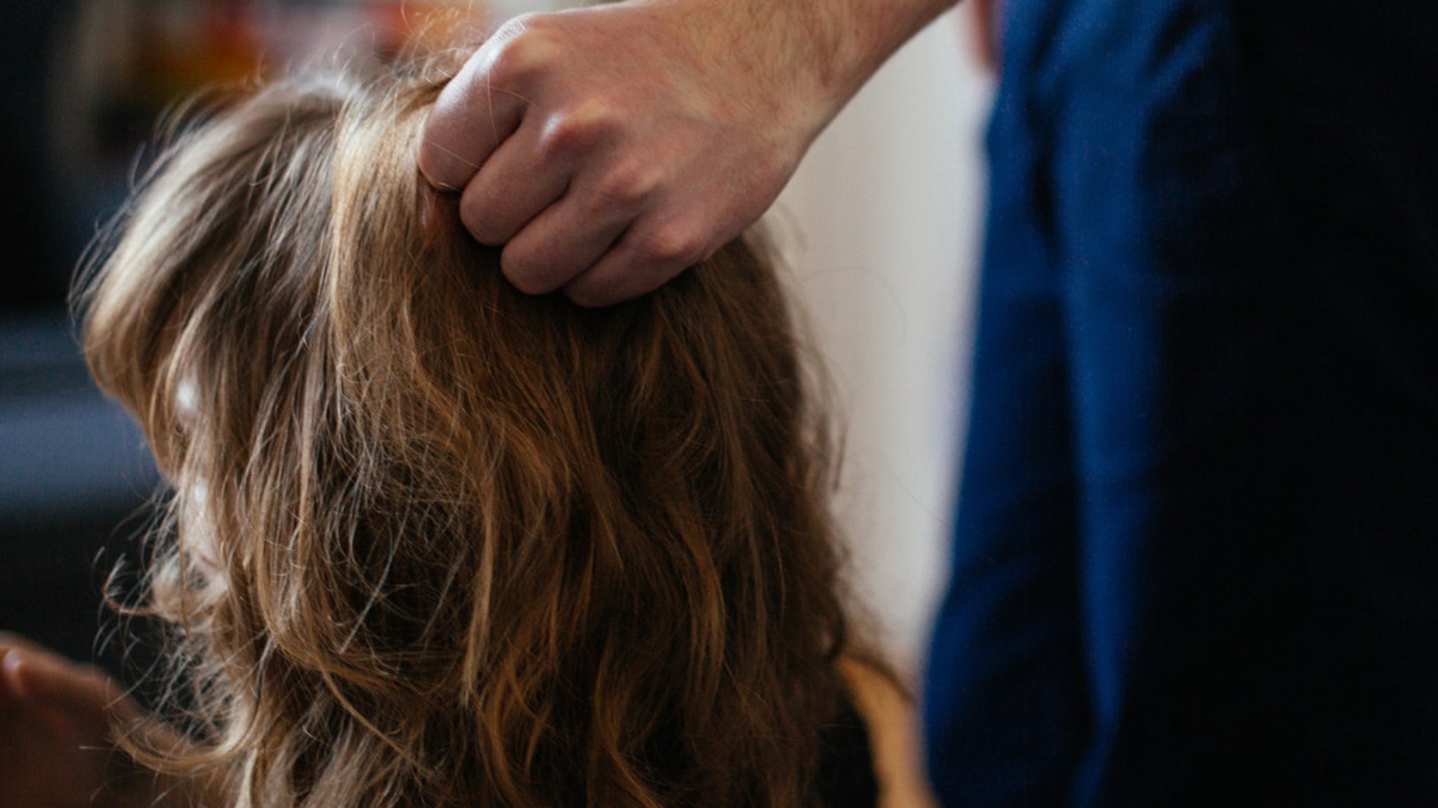 Eine Person zieht ein Mädchen gewaltsam an den Haaren (Symbolbild).