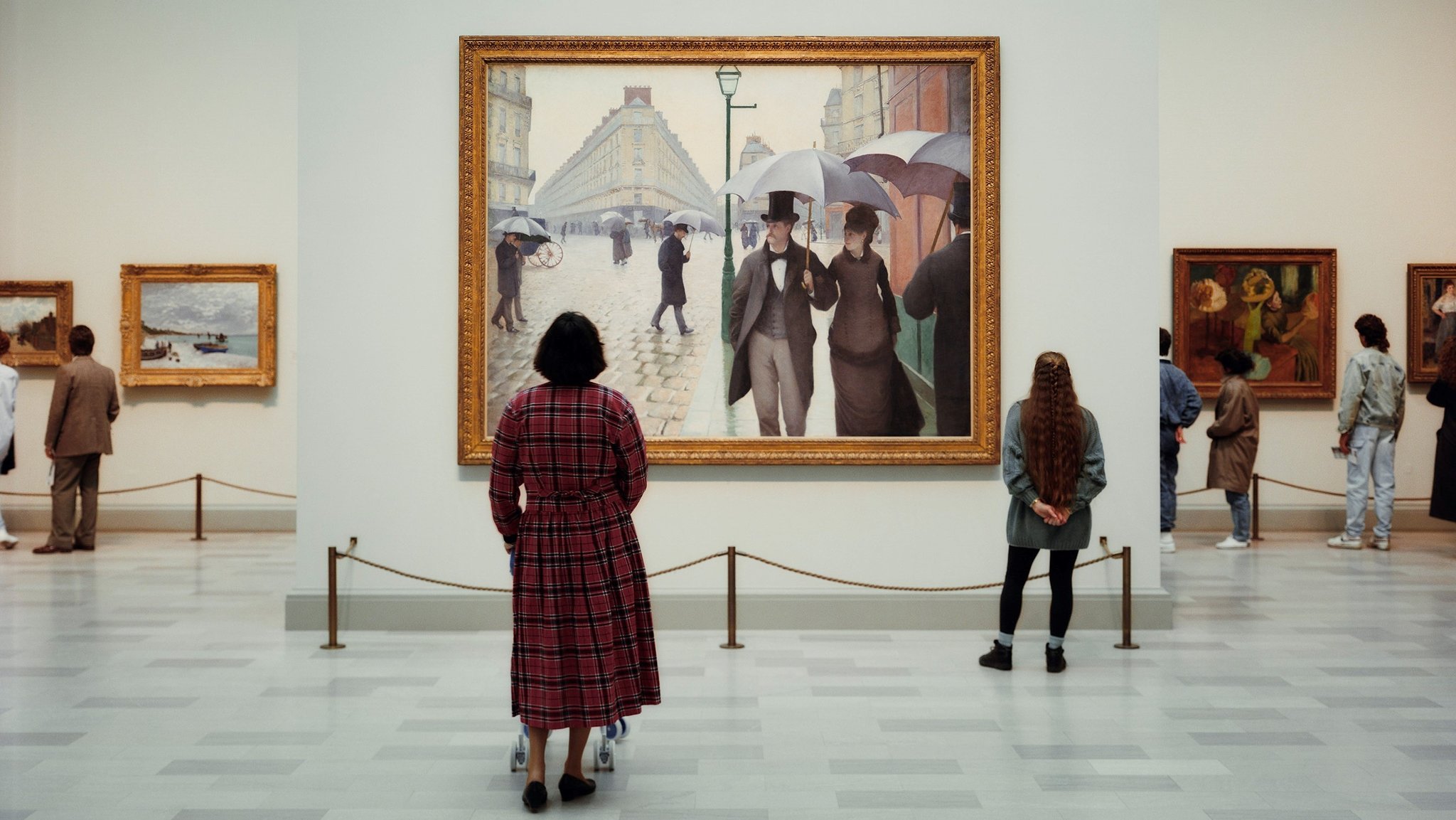 Menschen im Museum blicken auf ein Gemälde