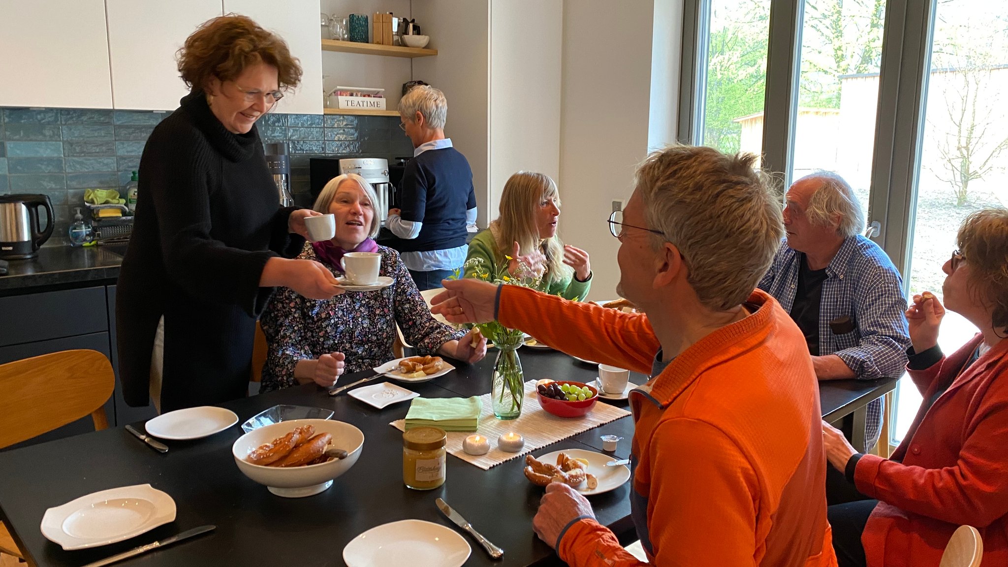 Die Bewohner des Mehrgenerationenhauses in Unterwössen sitzen um einen Tisch beim Frühstück.