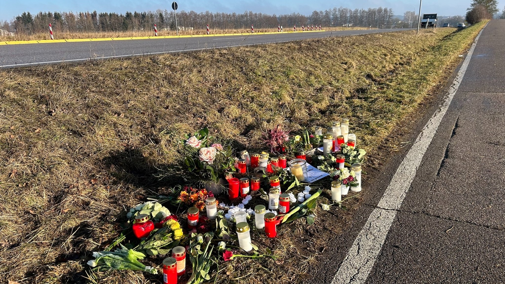 Unfallstelle auf der B14 nahe Ansbach mit Kerzen und Blumen für die Verstorbene.