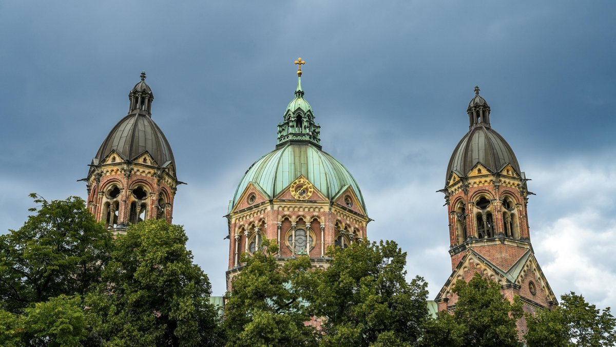 Stadtansicht von München: Die Lukaskirche, die größte evangelische Kirche Münchens. Dunkel bewölkter Himmel