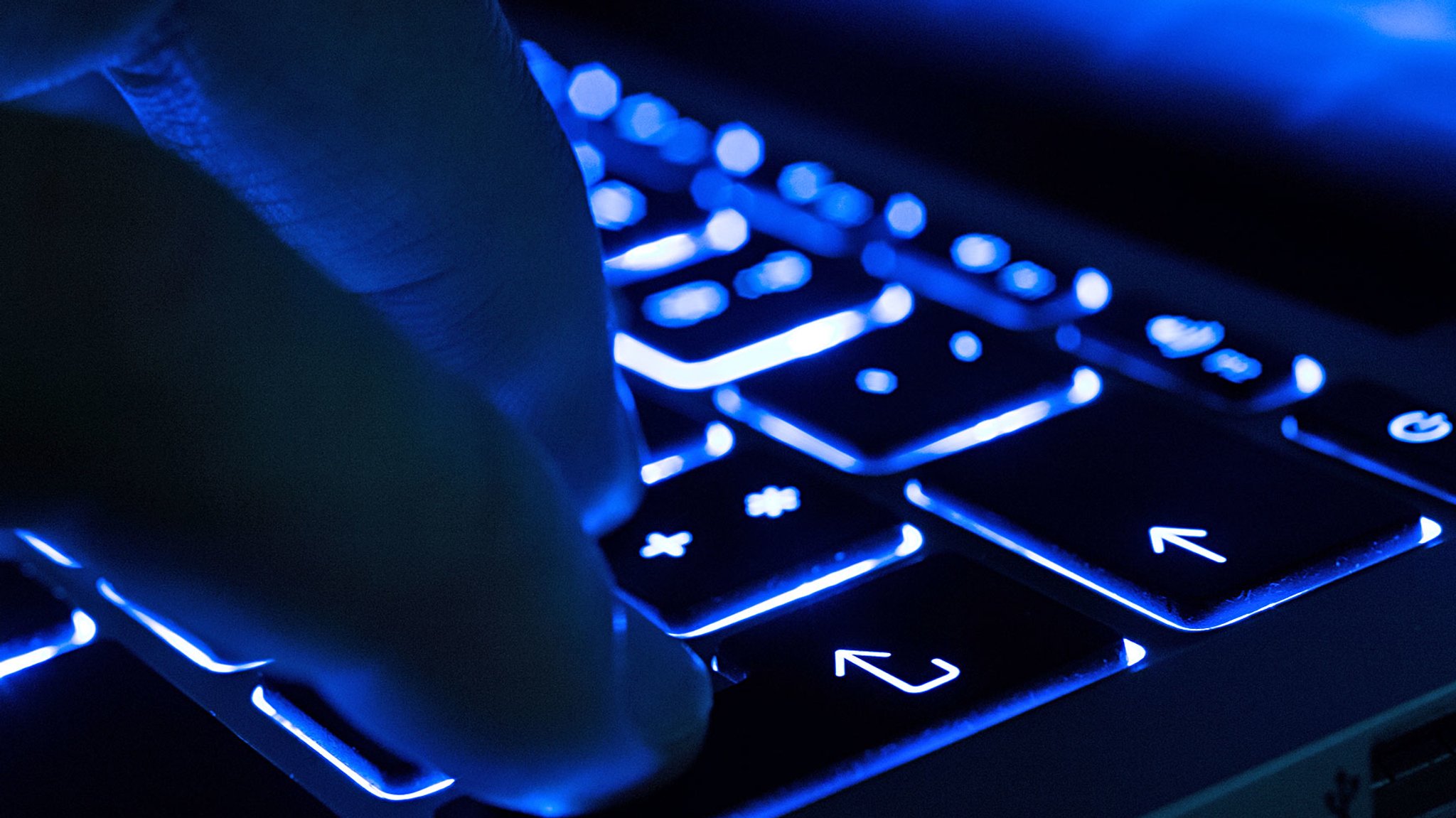Mann tippt auf beleuchteter Tastatur