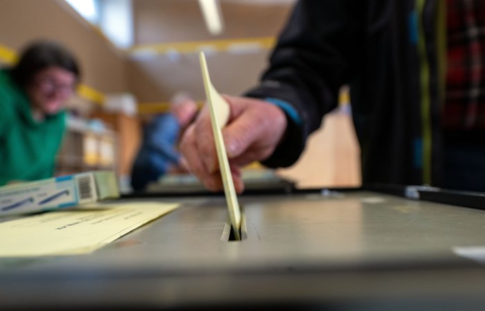 Ein Mann wirft einen ausgefüllten Wahlzettel in eine Wahlurne. | Bild: picture alliance/dpa | Pia Bayer Ein Mann wirft einen ausgefüllten Wahlzettel in eine Wahlurne.