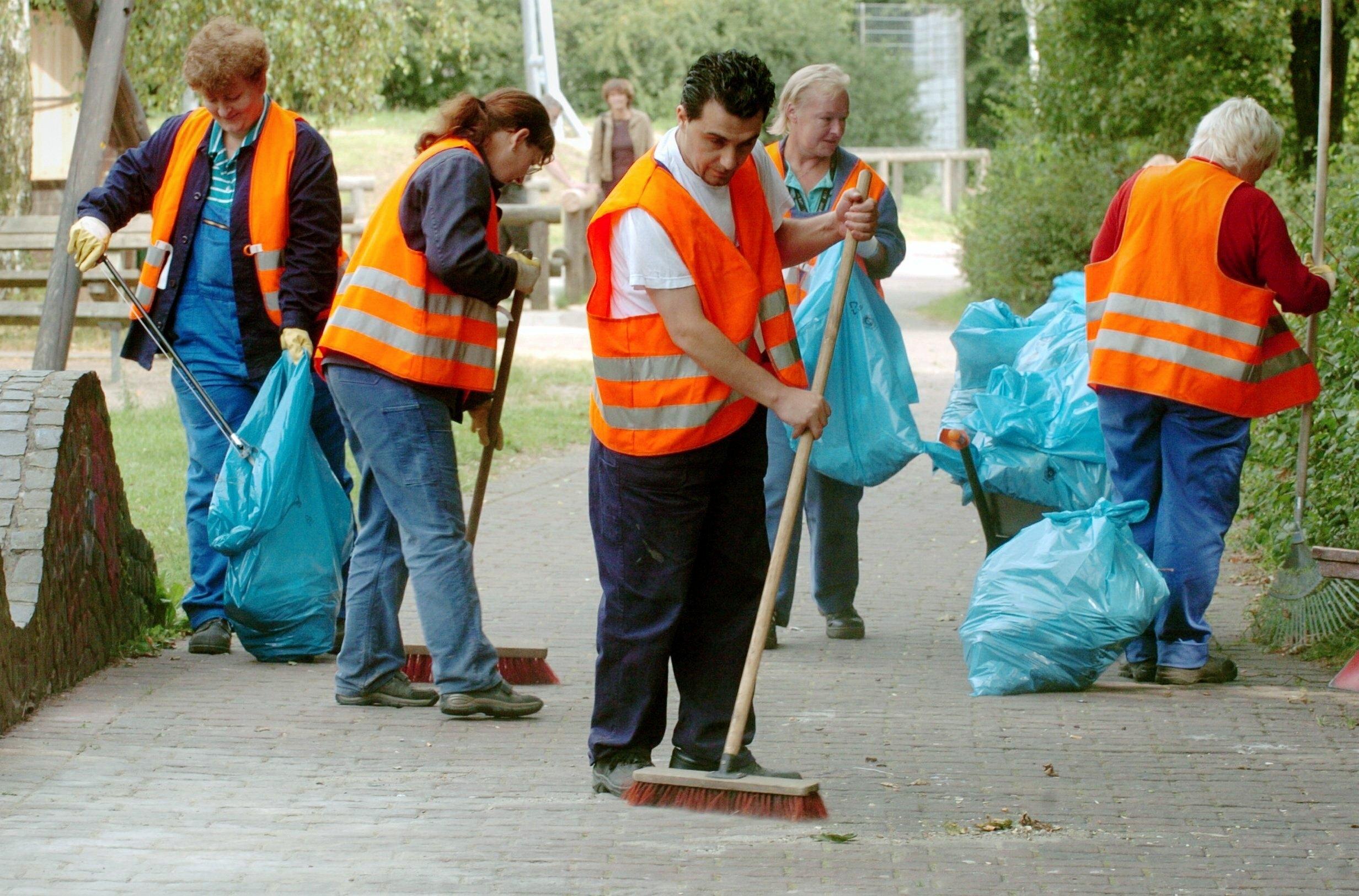Symbolbild: Gemeinnützige Arbeit – Personen mit Besen und Mülltüten