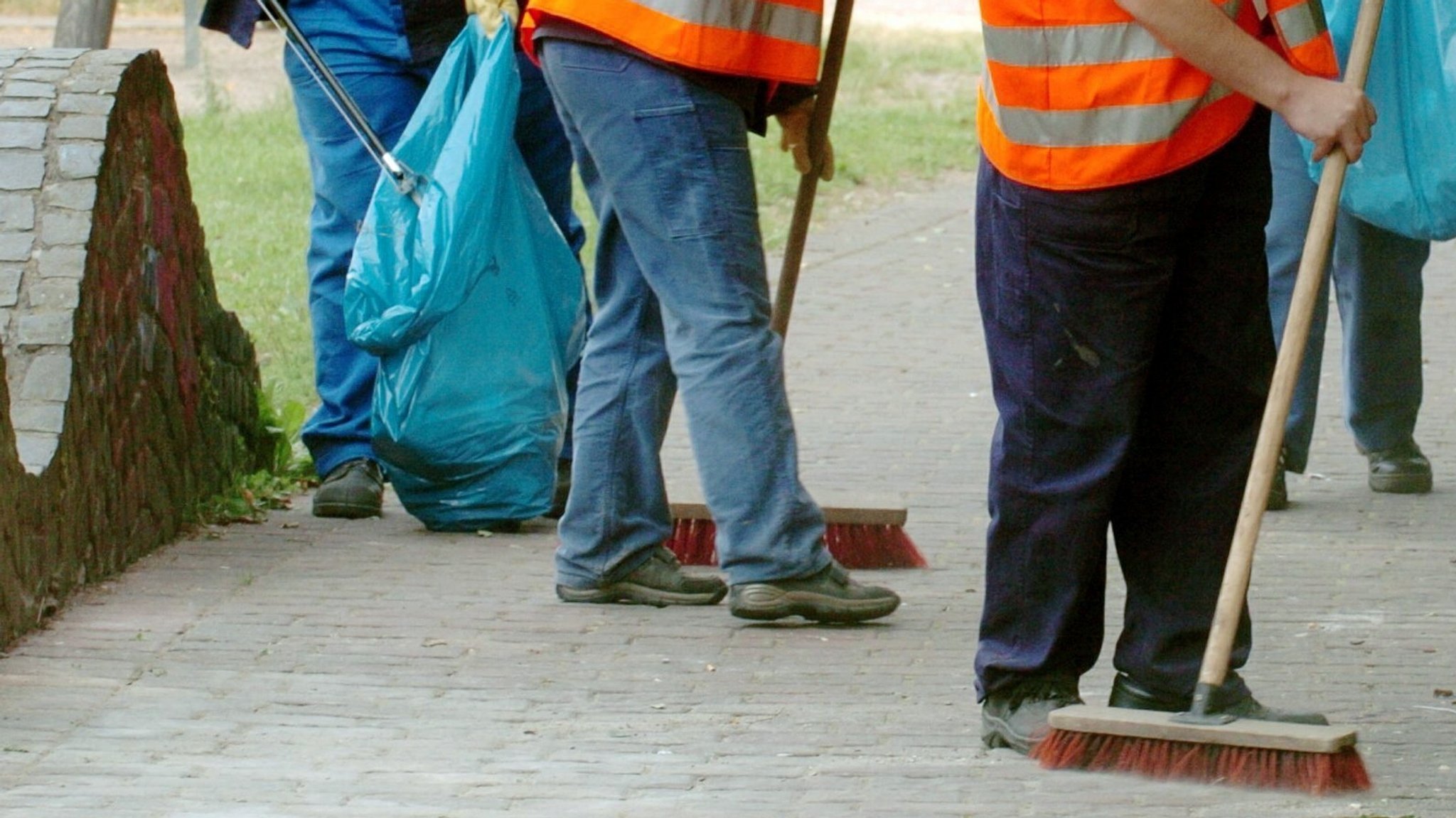 Symbolbild: Gemeinnützige Arbeit – Personen mit Besen und Mülltüten