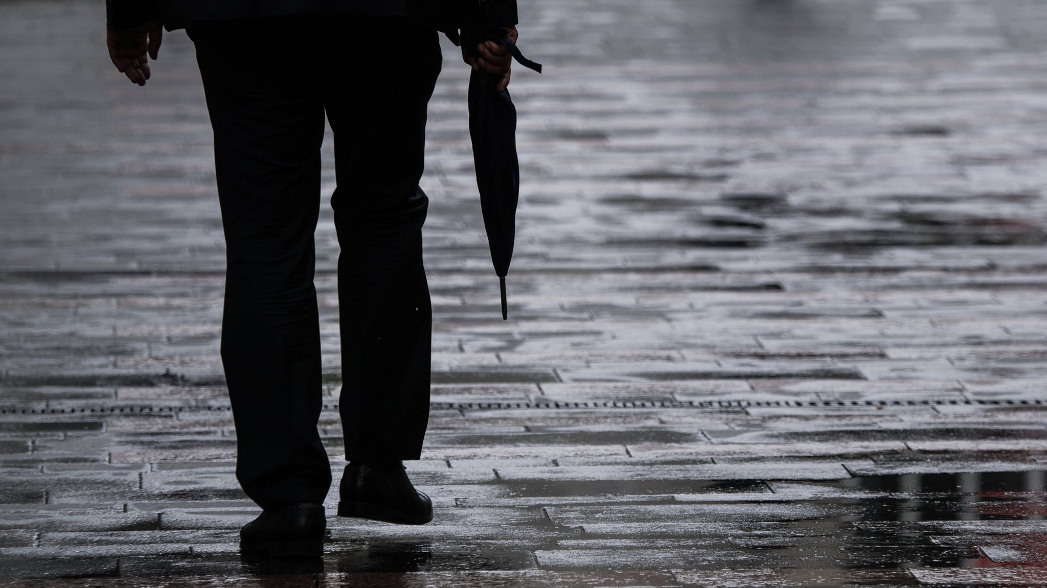 ARCHIV - 13.08.2018, Rheinland-Pfalz, Mainz: Ein Passant geht mit einem Regenschirm in der Hand durch die Mainzer Fußgängerzone. (zu dpa: «Regen und einzelne Gewitter erwartet») Foto: Andreas Arnold/dpa +++ dpa-Bildfunk +++