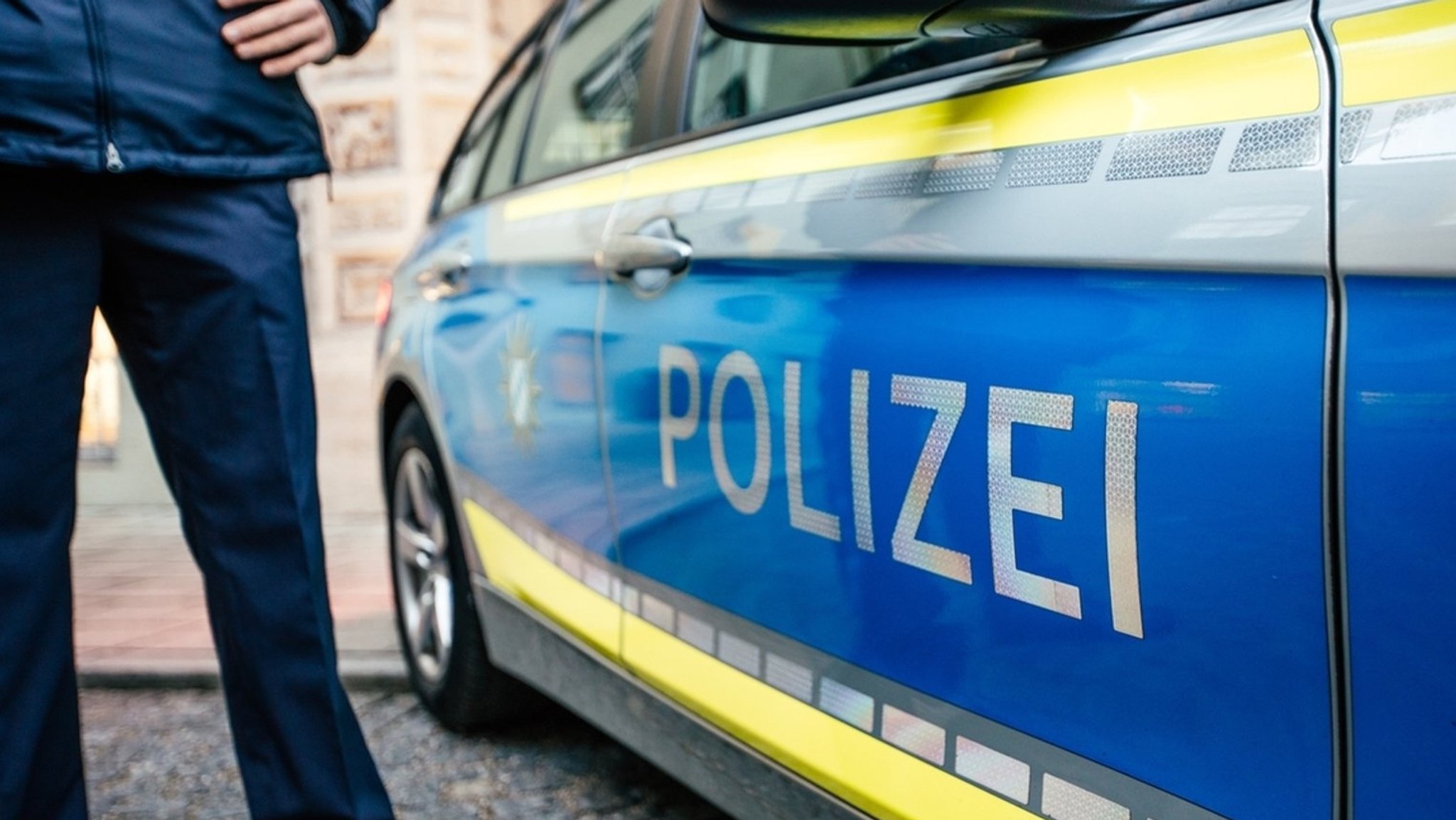 Beamter neben Polizeiauto