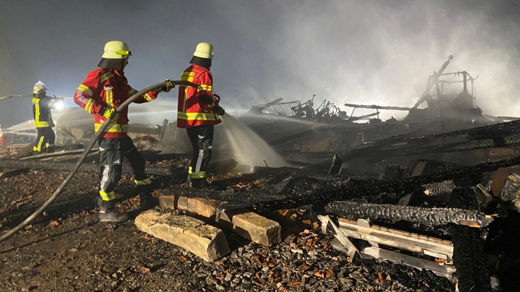 Die Feuerwehr löscht die letzten Glutnester in der Brandruine