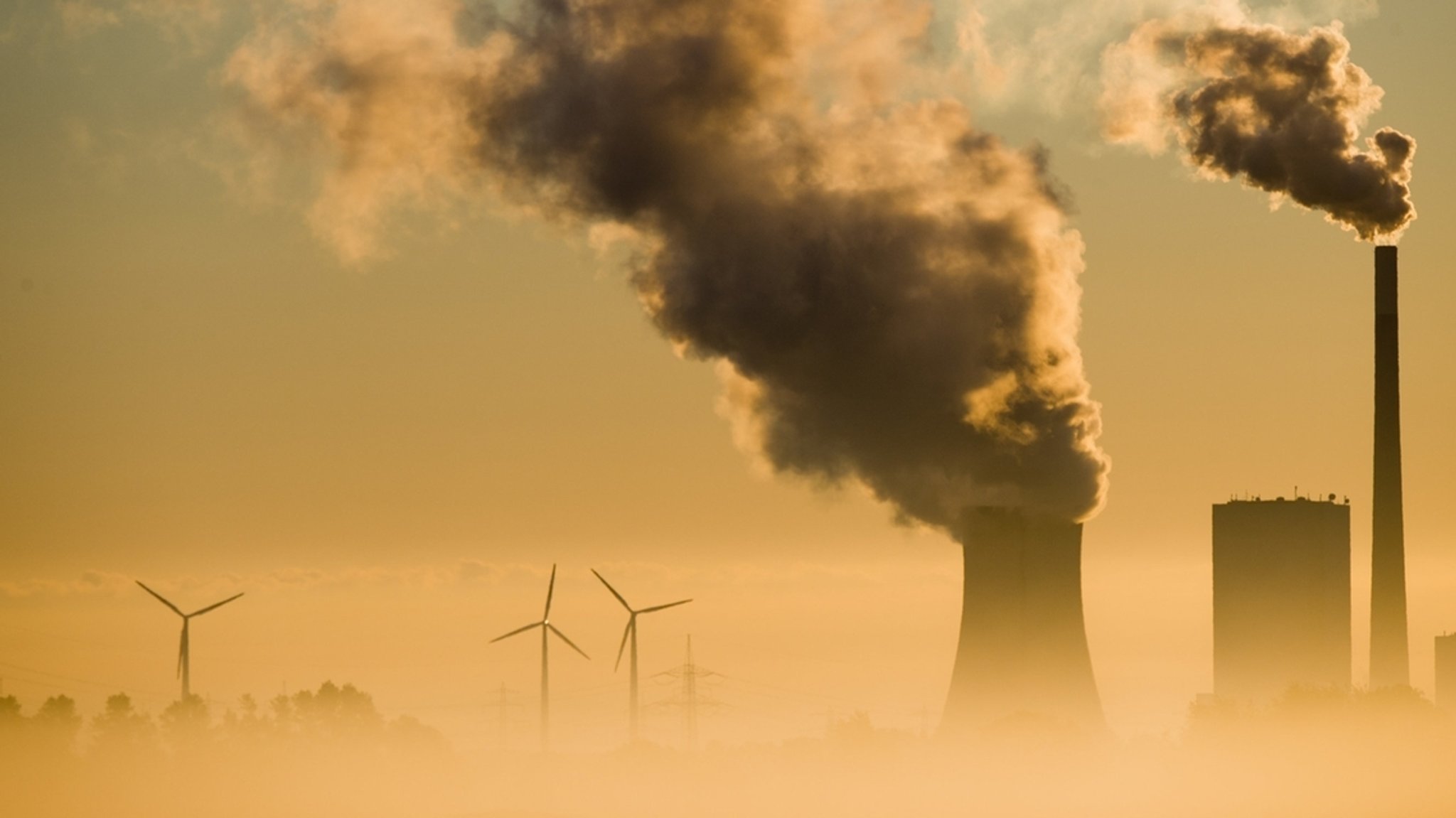 Ein Kohlekraftwerk und Windräder produzieren Strom. Mit dem Ausstieg aus der Kohle soll u.a. das Klimaschutzziel für Deutschland für 2030 erreicht werden.