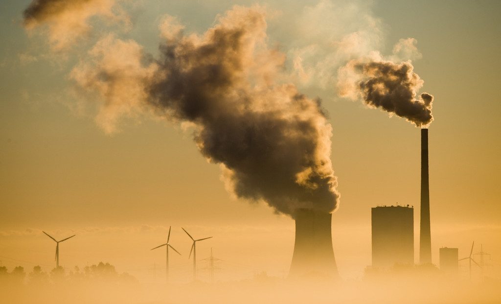 Ein Kohlekraftwerk und Windräder produzieren Strom. Mit dem Ausstieg aus der Kohle soll u.a. das Klimaschutzziel für Deutschland für 2030 erreicht werden.