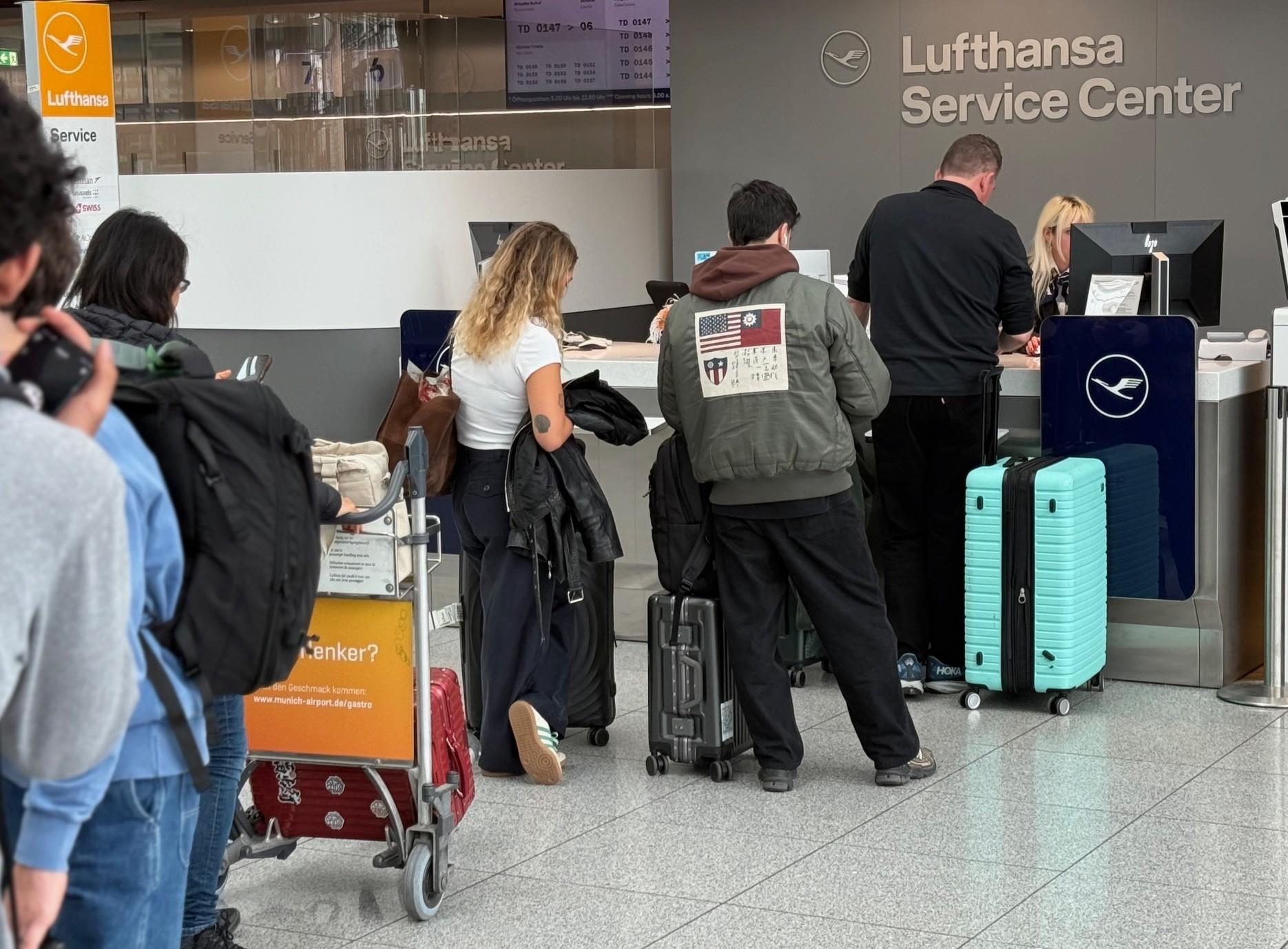 Fluggäste stehen am Flughafen München Schlange vor dem Service-Schalter der Lufthansa.