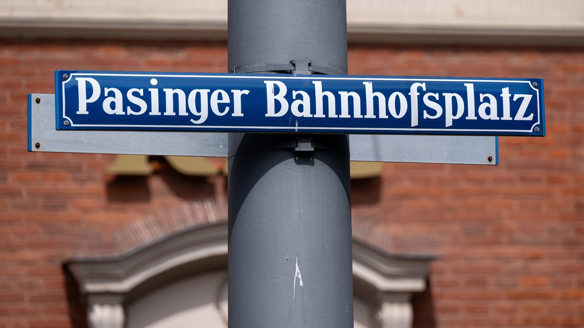 Ein Schild mit der Aufschrift "Pasinger Bahnhofsplatz" steht vor dem Bahnhof München-Pasing. 