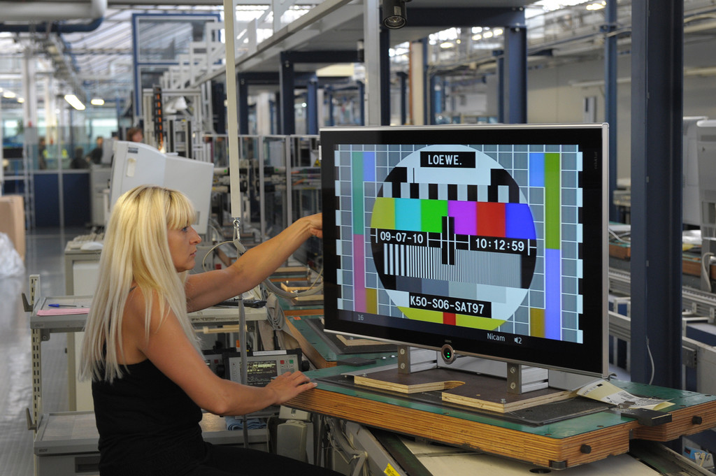 Eine Mitarbeiterin führt im Jahr 2010 in der Produktion in der Loewe-Firmenzentrale im oberfränkischen Kronach Funktionstests an einem "Loewe Individual"-Flachbildfernseher durch, auf dem ein Testfotoangezeigt wird