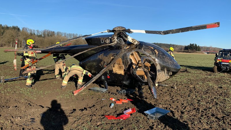 Die Feuerwehr versucht, den verunglückten Hubschrauber wieder aufzustellen. | Bild: Polizei Mühldorf am Inn Die Feuerwehr versucht, den verunglückten Hubschrauber wieder aufzustellen.