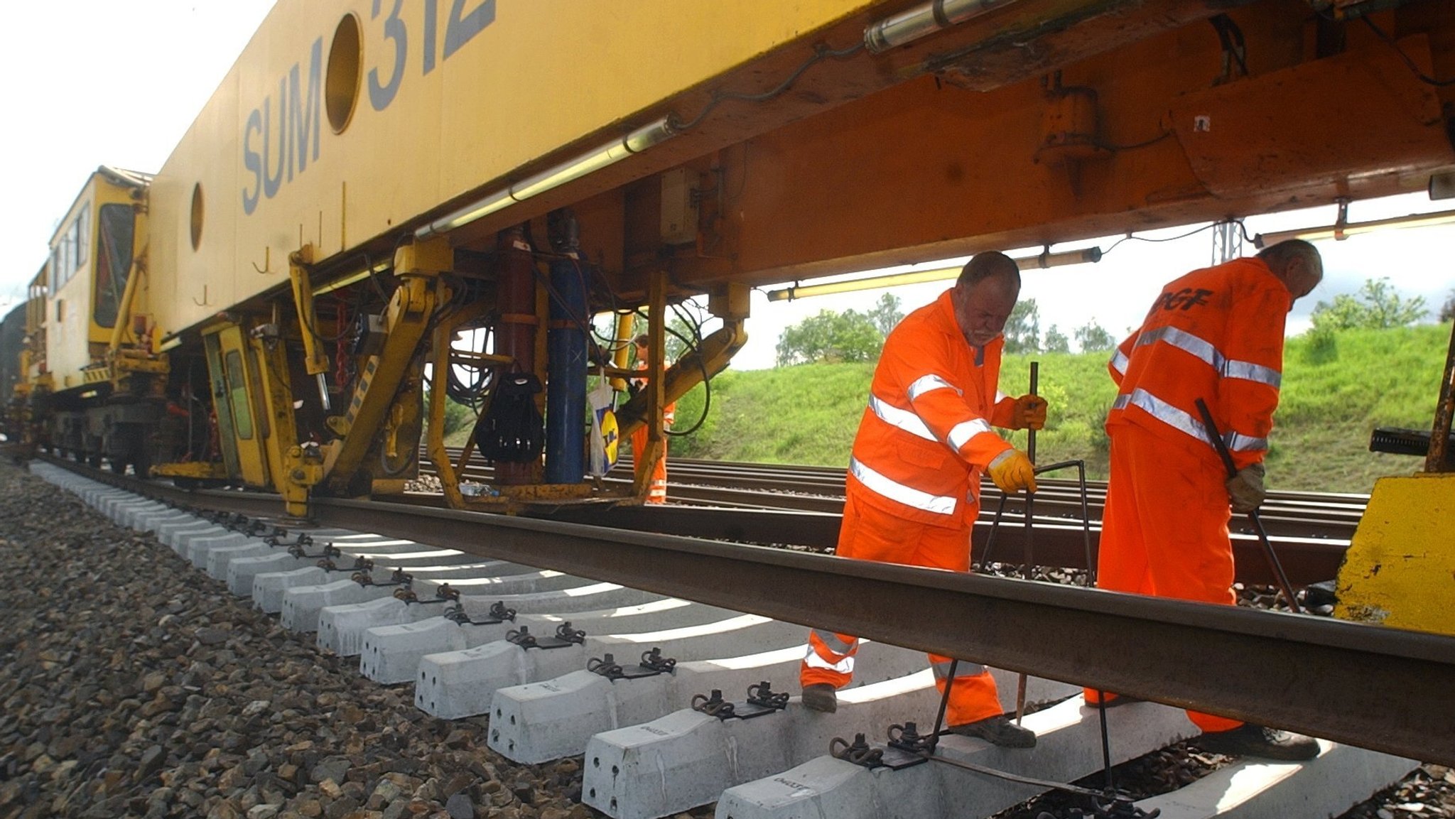 Archivbild: Zwei Maschinisten prüfen am 08.05.2004 das korrekte Auslegen der neuen Schwellen durch den Schnellumbauzug der Deutschen Gleis- und Tiefbau GmbH, einer Firma der Deutschen Bahn Gruppe, zwischen den Bahnhöfen Berlin-Schönefeld und Genshagen.