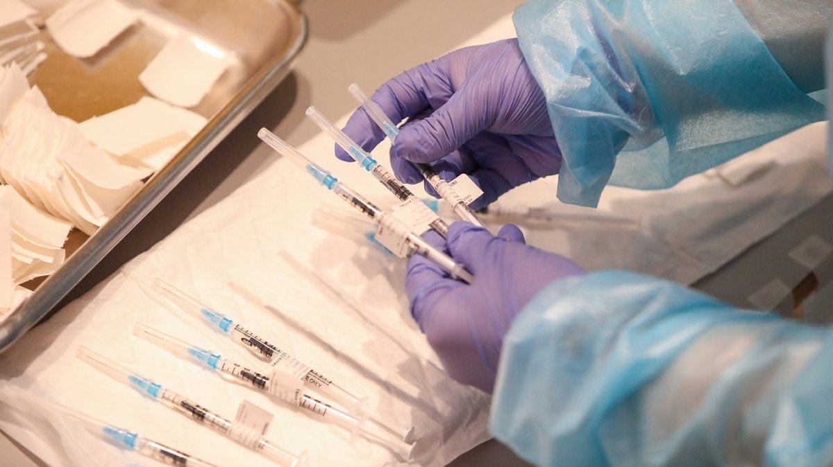 Ein Mitarbeiter des Gesundheitswesens bereitet Spritzen mit dem Corona-Impfstoff von Biontech/Pfizer vor (Symbolbild)