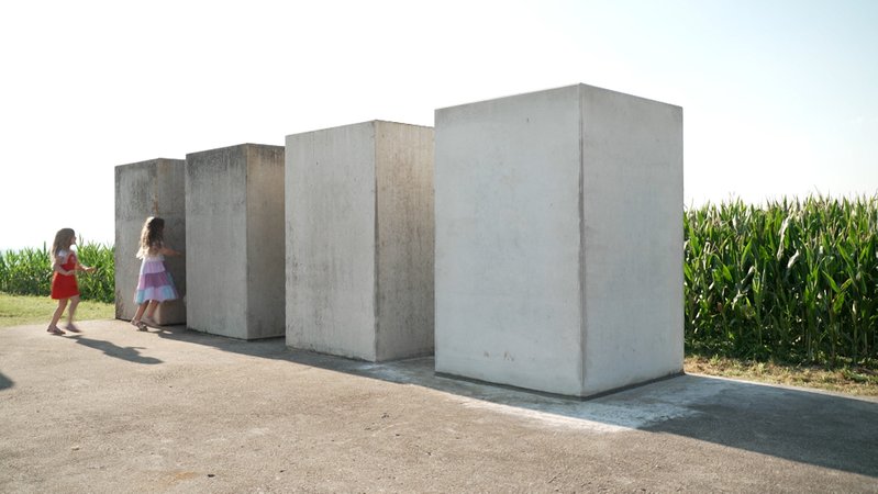 Vier große Steinquader stehen auf einer Betonplatte