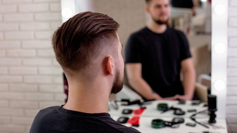 Ein Mann sitzt vor dem Spiegel beim Friseur. | Bild: stock.adobe.com/Galina Ein Mann sitzt vor dem Spiegel beim Friseur.
