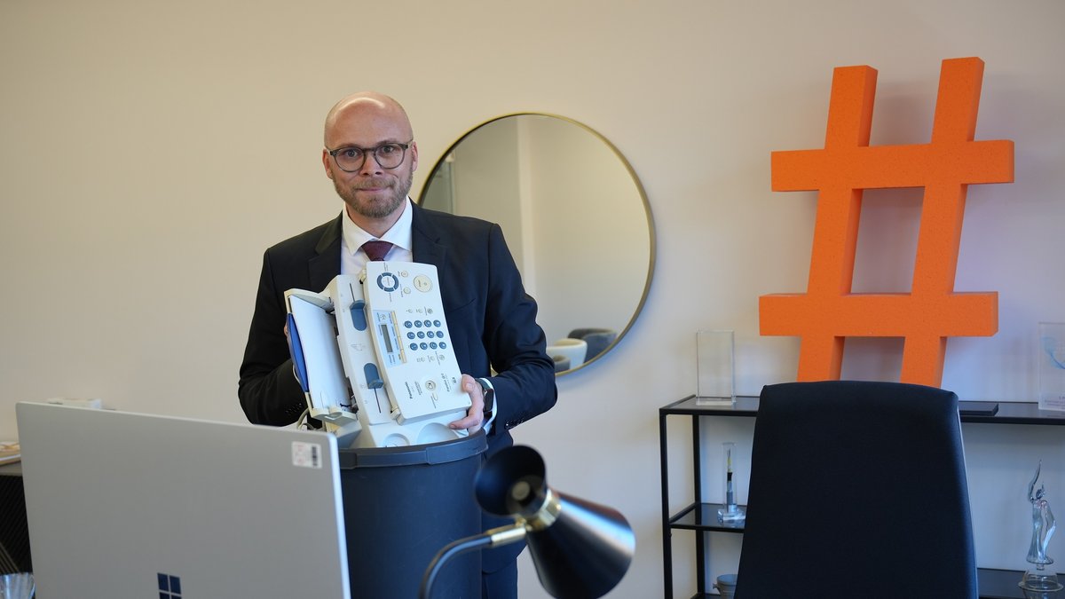 Bayerns Digitalminister Mehring wirft ein Faxgerät in den Papierkorb