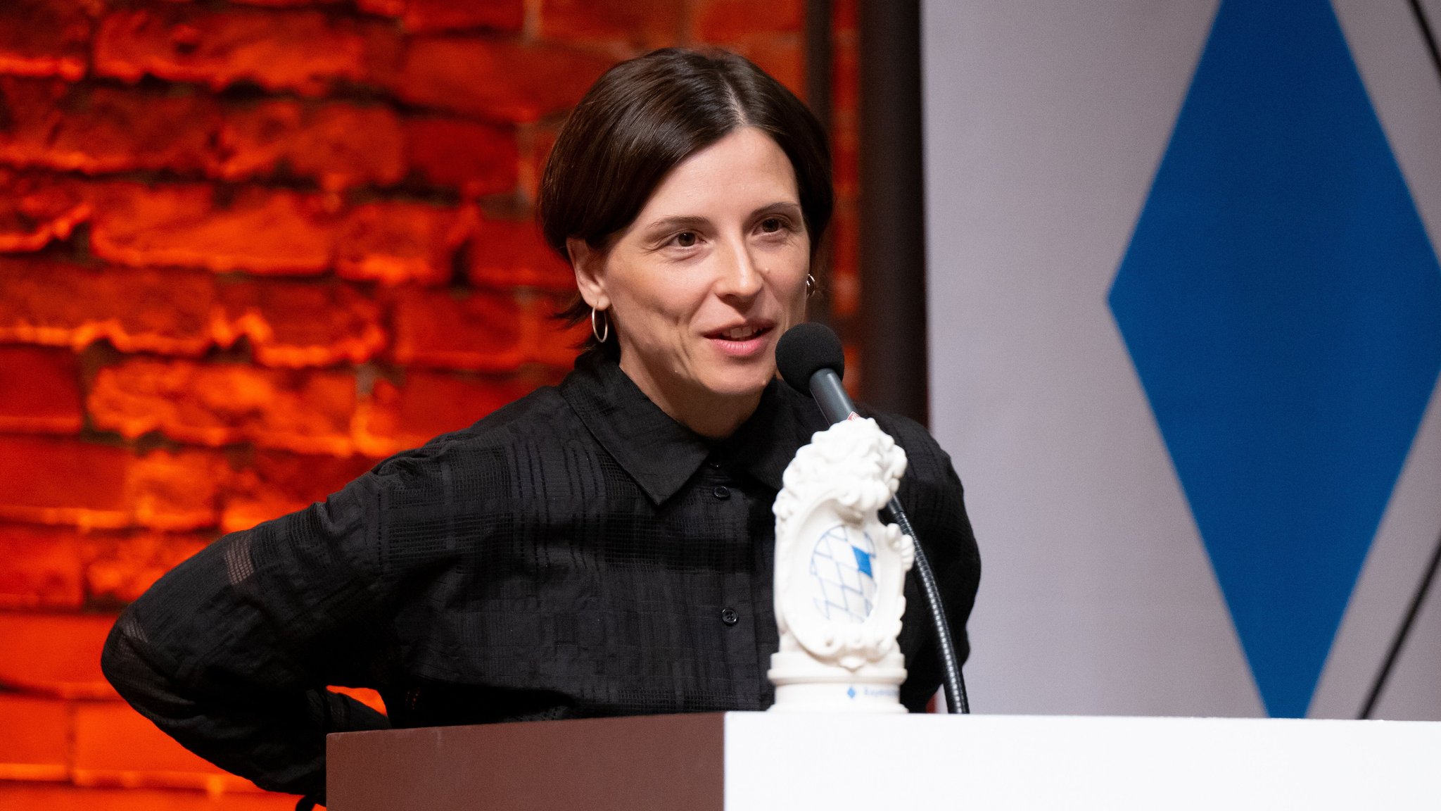 Schriftstellerin Dorothee Elmiger steht an einem Pult, darauf steht ein weißer Porzellanlöwe.