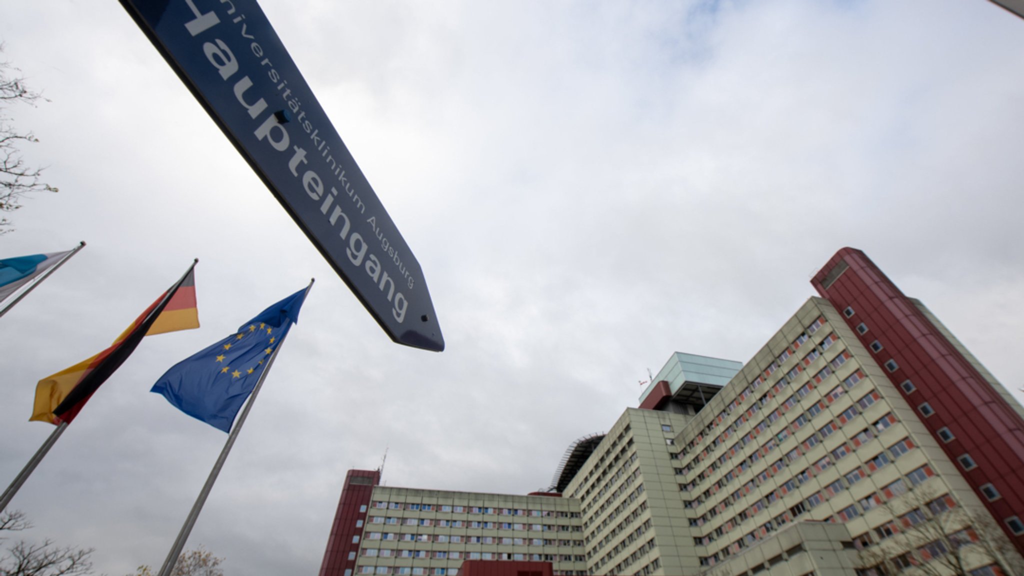 Ein Schild weist auf den Haupteingang des Universitätsklinikums in Augsburg hin