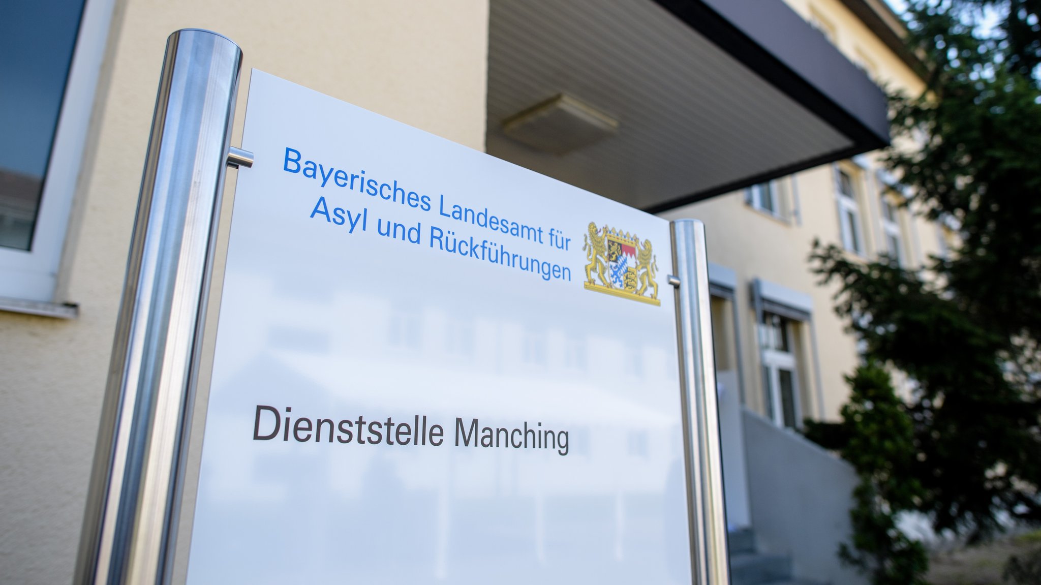 Bayern, Ingolstadt: Ein Schild mit der Aufschrift "Bayerisches Landesamt für Asyl und Rückführungen - Dienststelle Manching" ist am Rande der Gründungsfeier des Landesamtes für Asyl und Rückführungen im Transitzentrum Manching vor dem Gebäude zu sehen.