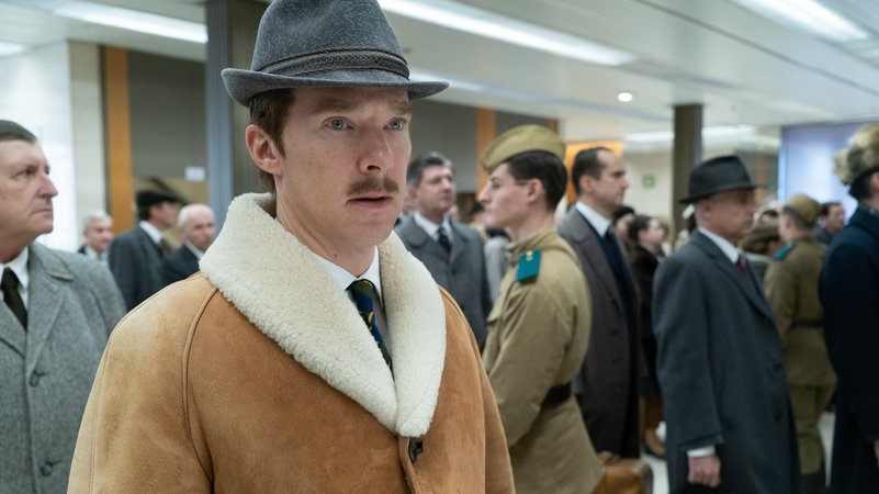 Benedict Cumberbatch mit Hut und Wintermantel in einer Flughafenhalle.