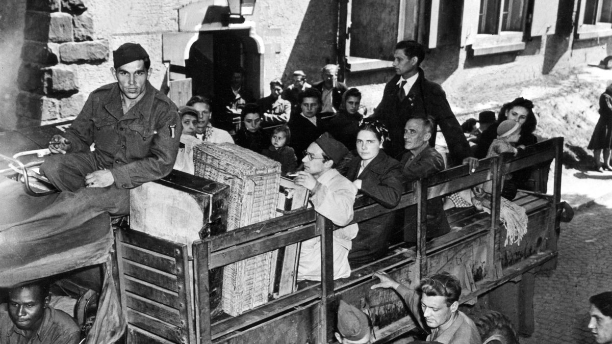 Eine Gruppe Displaced Persons, die in einem Lager untergebracht waren, vor ihrer Abreise in ihre Heimat. Aufgenommen 1945