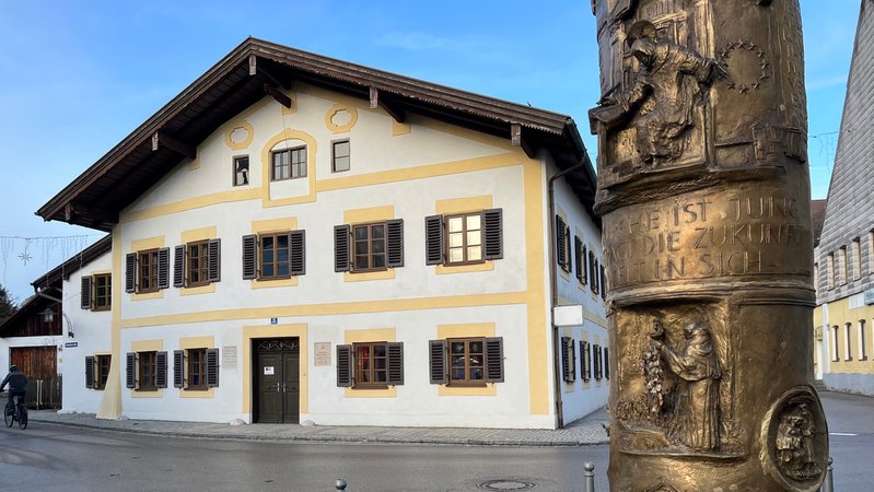 Das Geburtshaus von Joseph Ratzinger in Marktl, im Vordedrgrund die Benediktsäule.