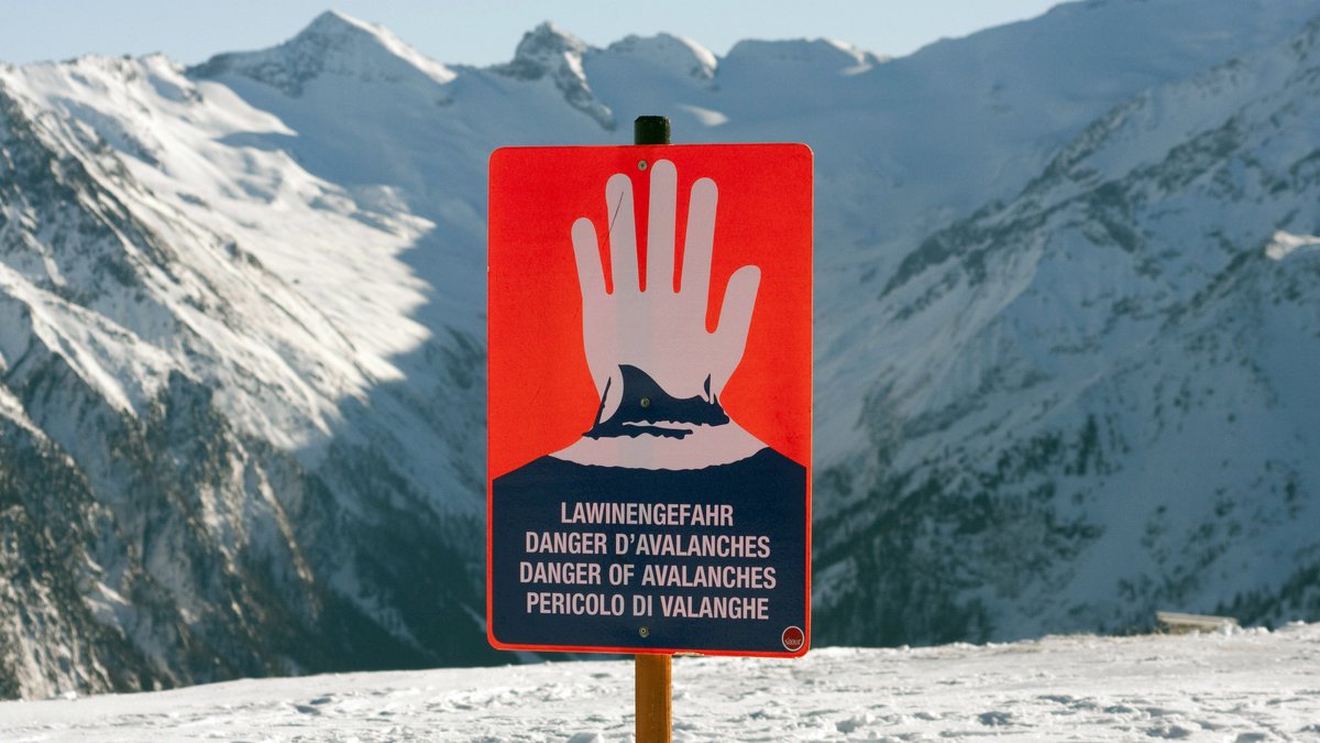 Ein Schild in den Alpen das vor Lawinengefahr warnt (Archivaufnahme).